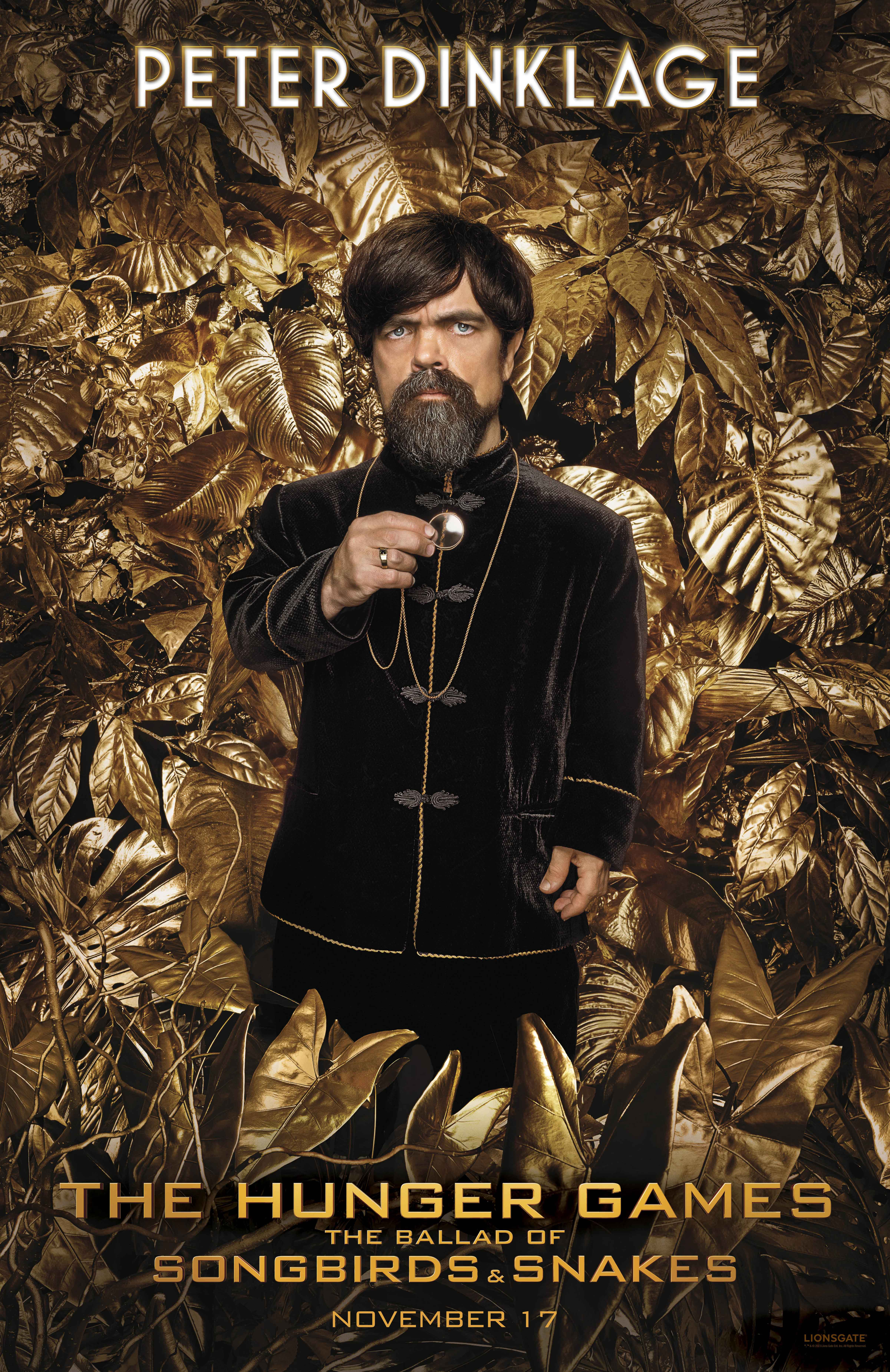 Peter Dinklage in a promotional phone wallpaper for The Hunger Games: The Ballad of Songbirds & Snakes surrounded by golden leaves.