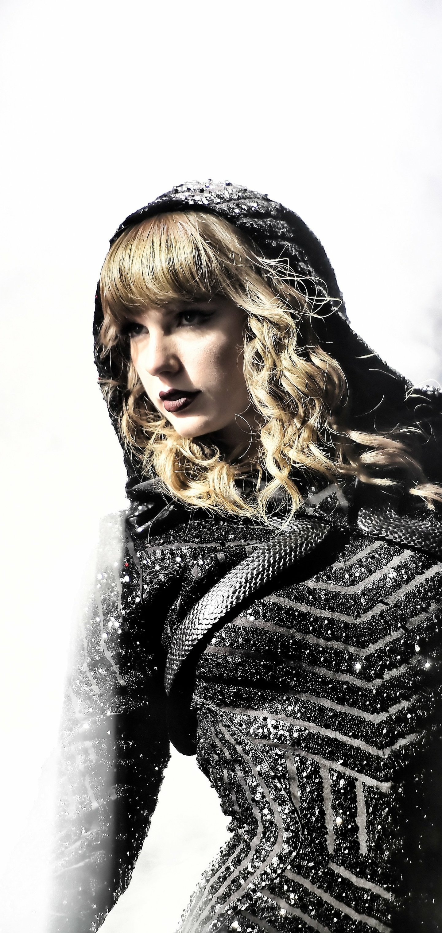 Phone wallpaper featuring Taylor Swift in a dark, textured outfit with a hood, surrounded by a soft, snowy atmosphere, designed for iPhone and Android screens.