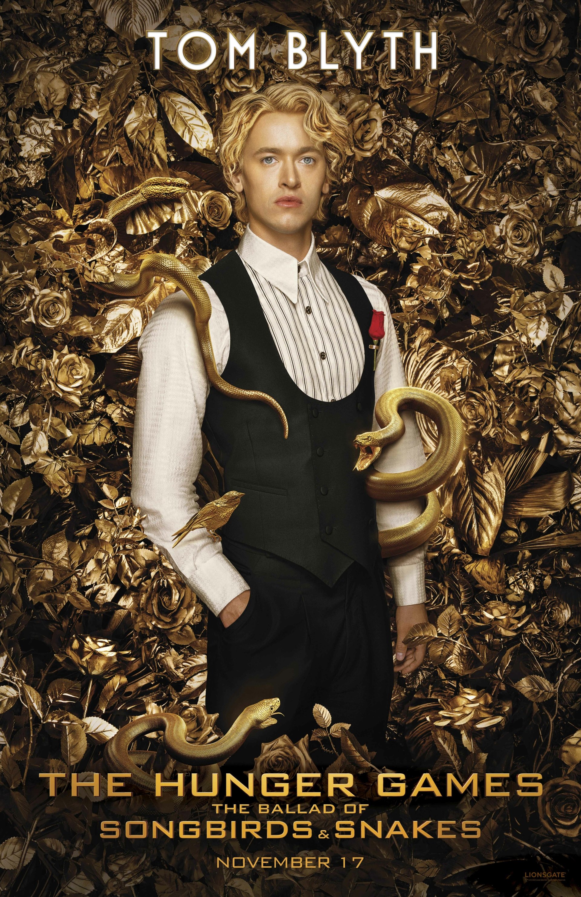 Promotional phone wallpaper for The Hunger Games: The Ballad of Songbirds & Snakes featuring a young man with golden snakes, with a release date of November 17.