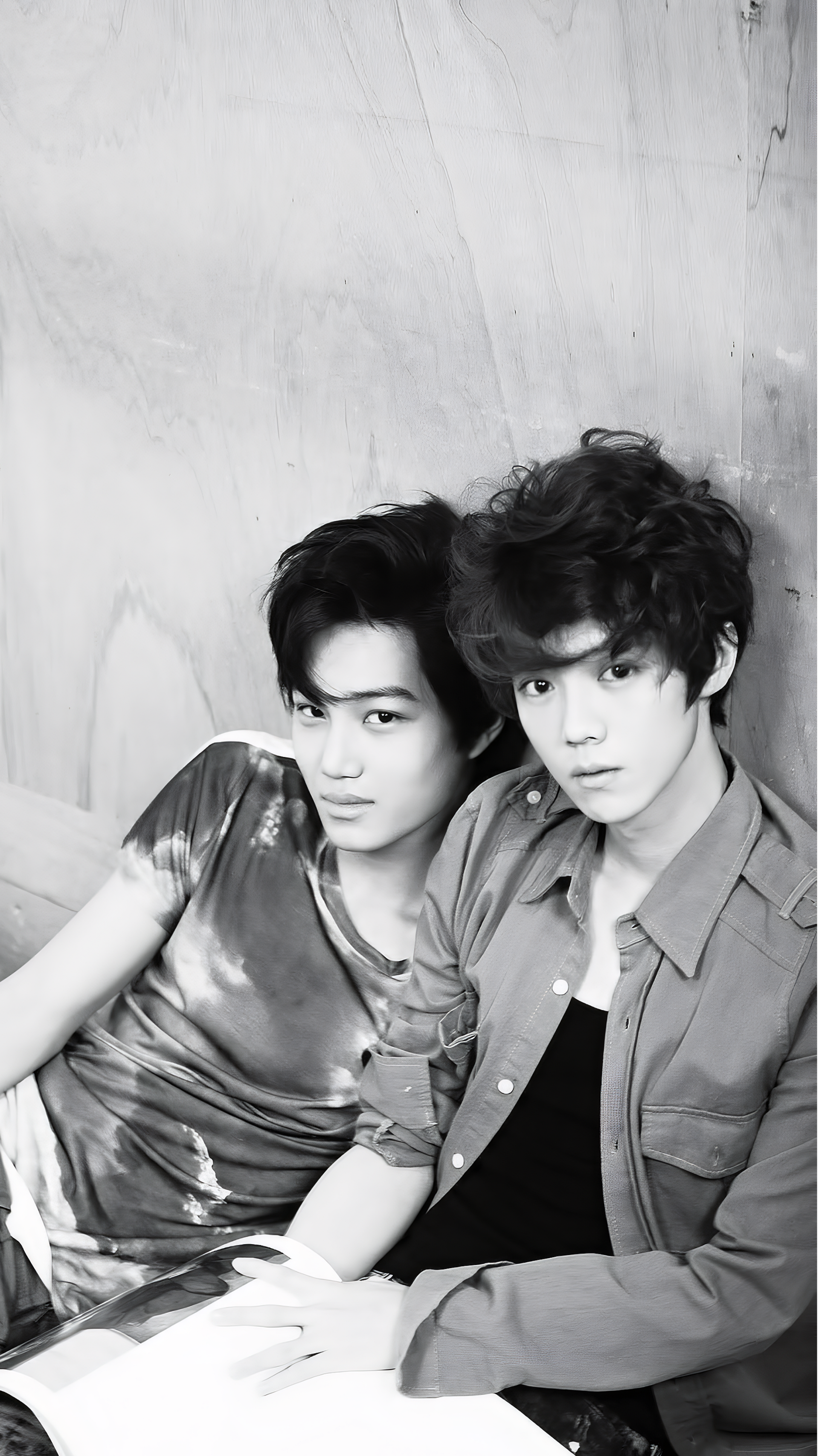A monochrome photo of EXO members Kai and Suho from a photoshoot for Mama, featured as a stylish phone wallpaper. Both artists exude charisma in their casual outfits.