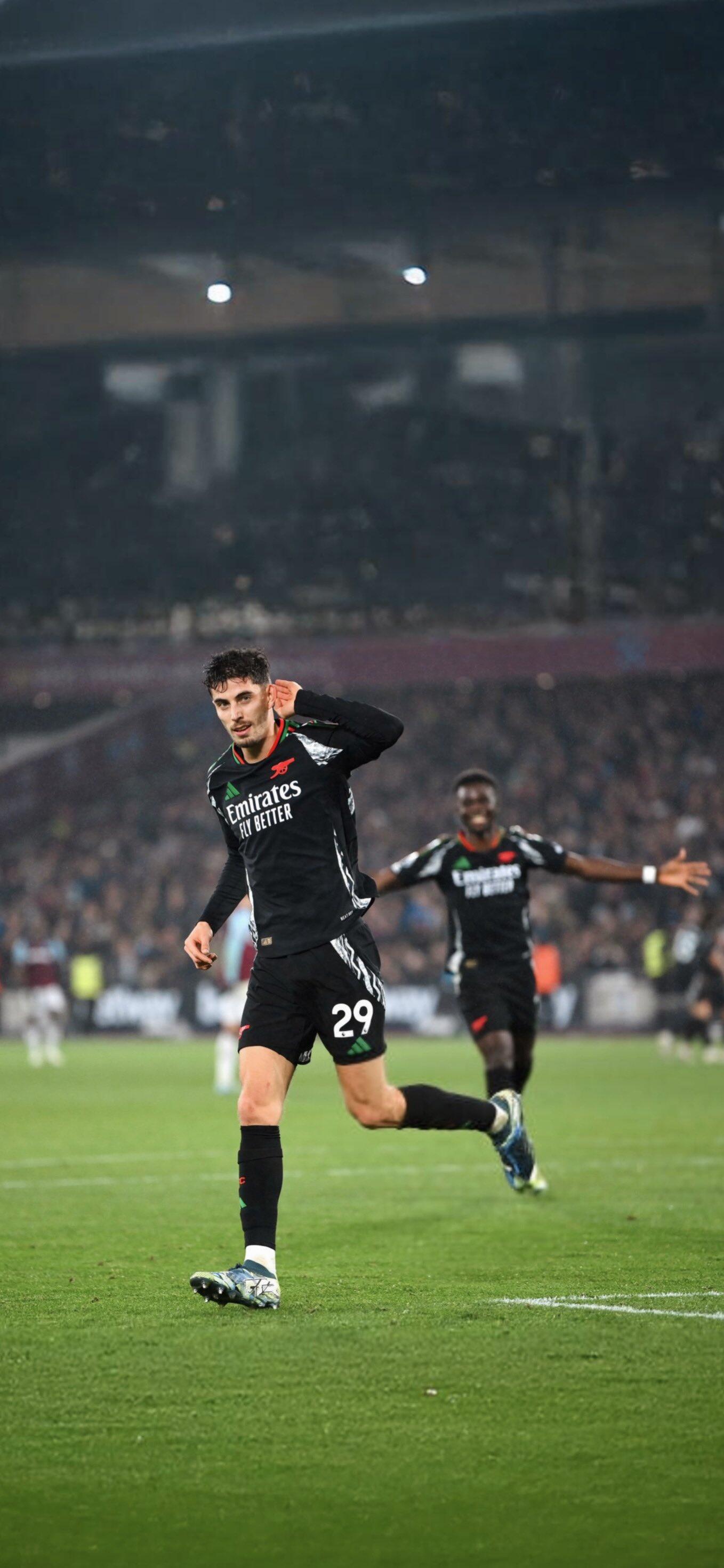 Phone wallpaper featuring Arsenal F.C. soccer player celebrating on the field during a night match, compatible with both iPhones and Android phones.