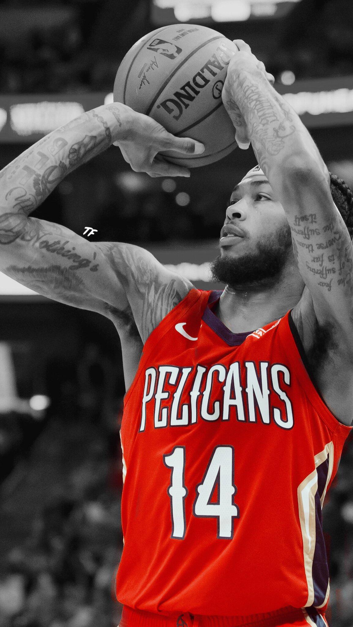 Brandon Ingram, wearing a New Orleans Pelicans jersey, prepares to shoot a basketball. This dynamic sports image captures his intense focus and athleticism.