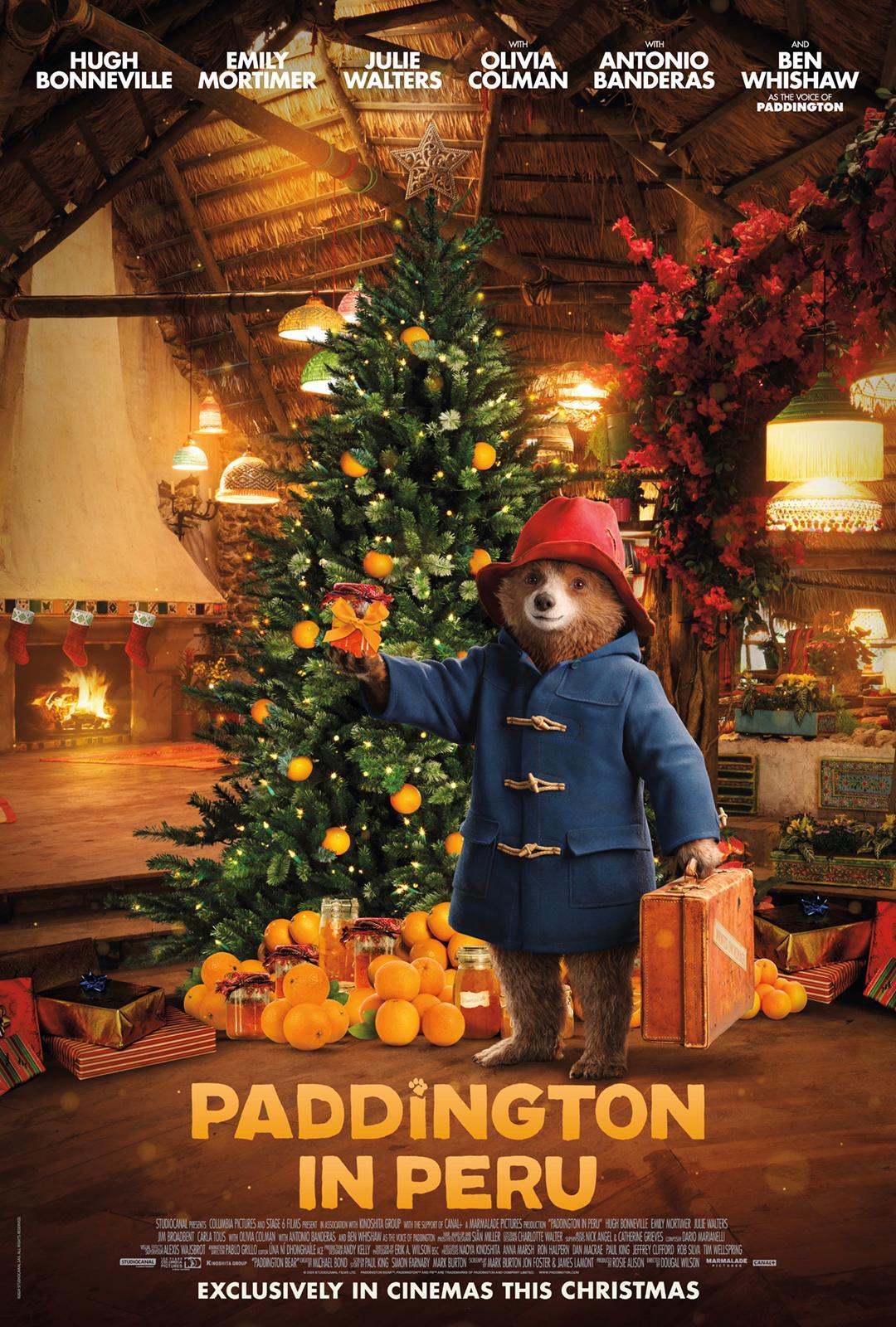 A cozy scene from Paddington in Peru, featuring Paddington Bear with a suitcase amidst a festive setting and a decorated Christmas tree. Enjoy this whimsical phone wallpaper.