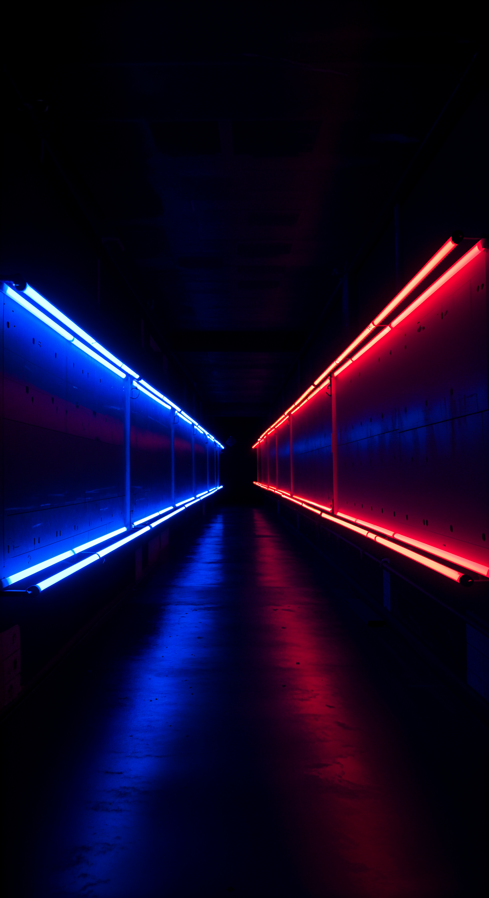 A dark corridor illuminated by glowing fluorescent blue and red lights creates a striking visual effect, making it an eye-catching phone wallpaper.