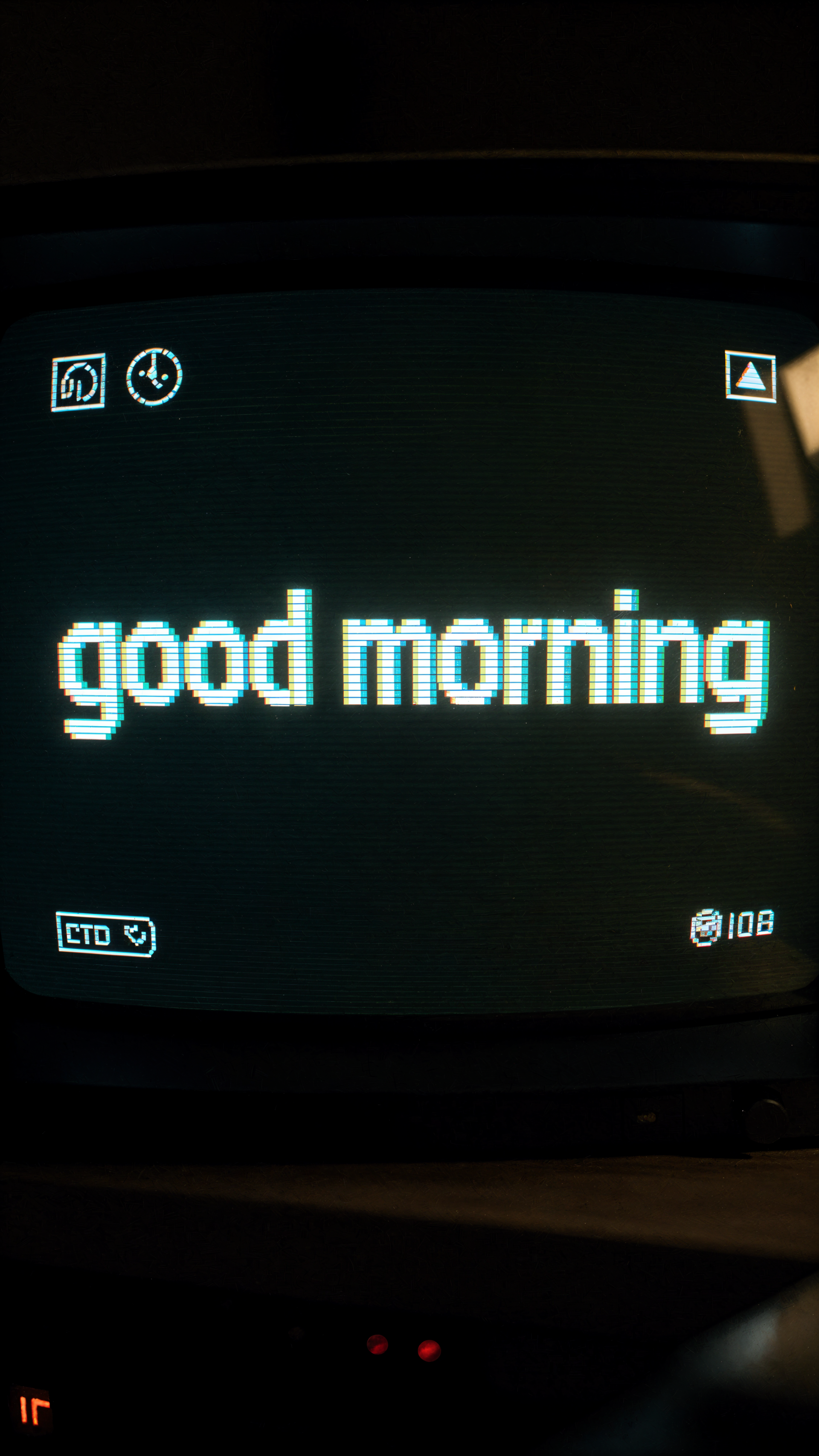 Phone wallpaper: pixelated teal good morning centered on a dark retro CRT-style screen with small UI icons.
