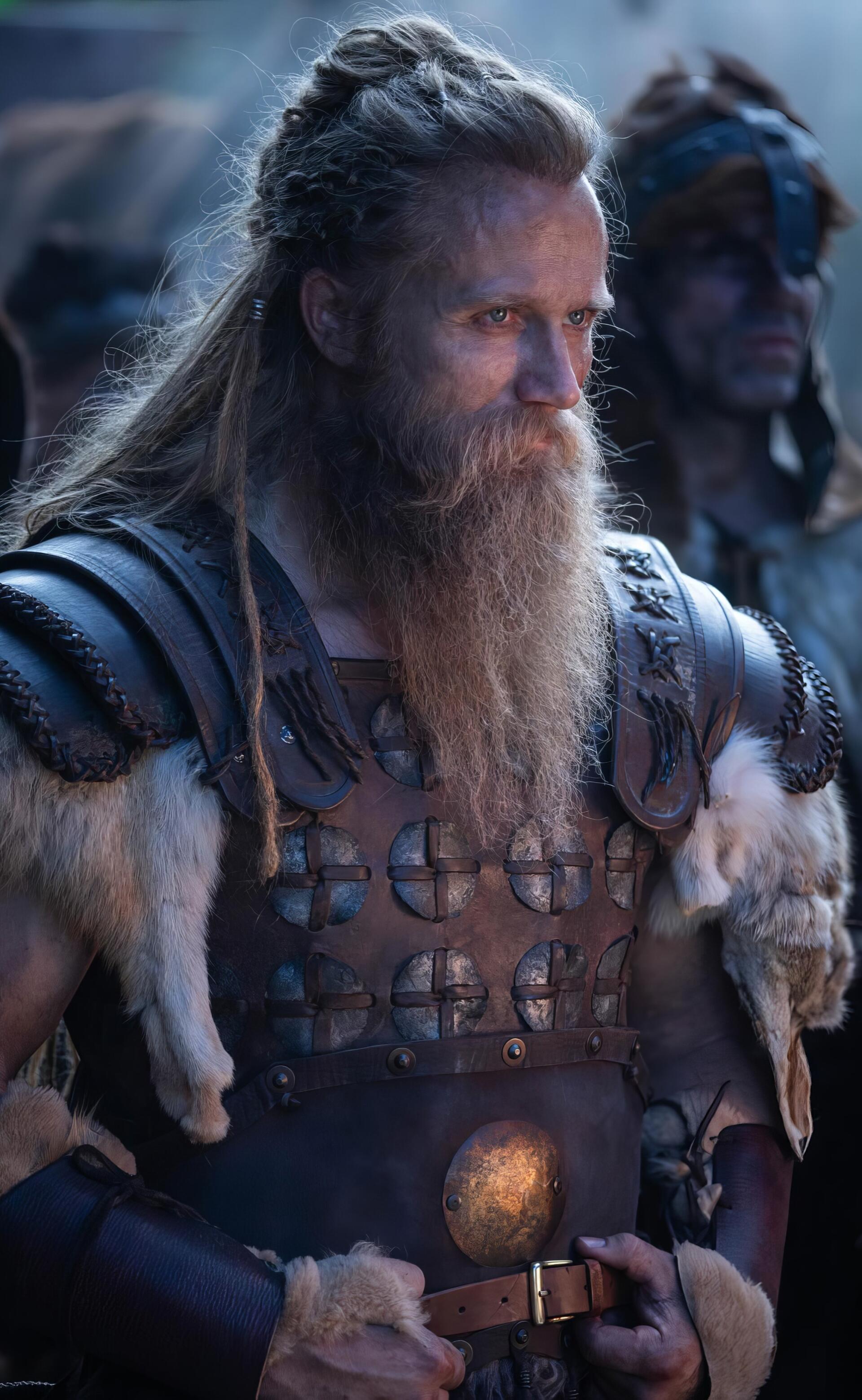 Phone wallpaper for TV show The Pendragon Cycle: Rise of the Merlin — bearded, braided warrior in fur-trimmed leather armor stares into a dim, battle-ready scene.