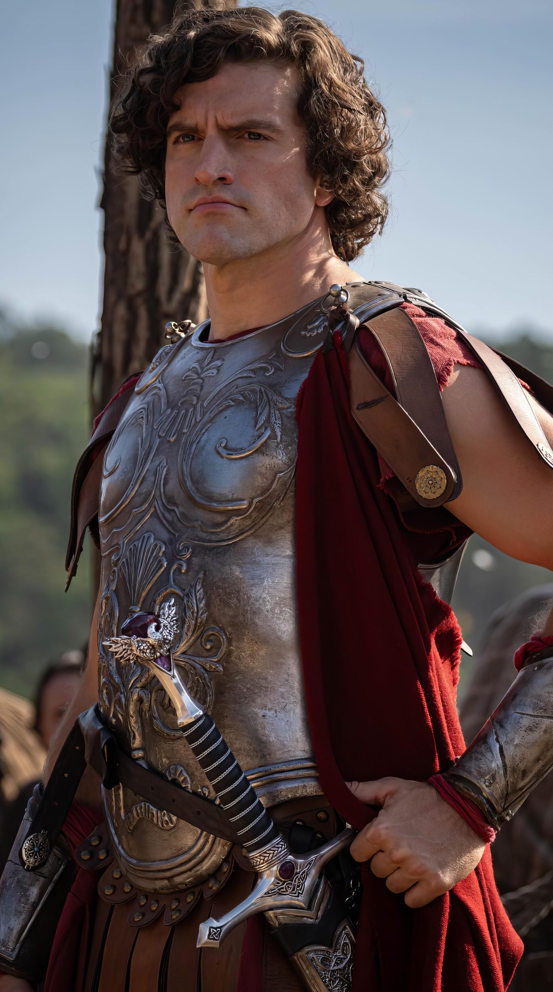 Phone wallpaper of a stern gladiator in ornate Roman-style armor and red cloak from the TV show The Pendragon Cycle: Rise of the Merlin