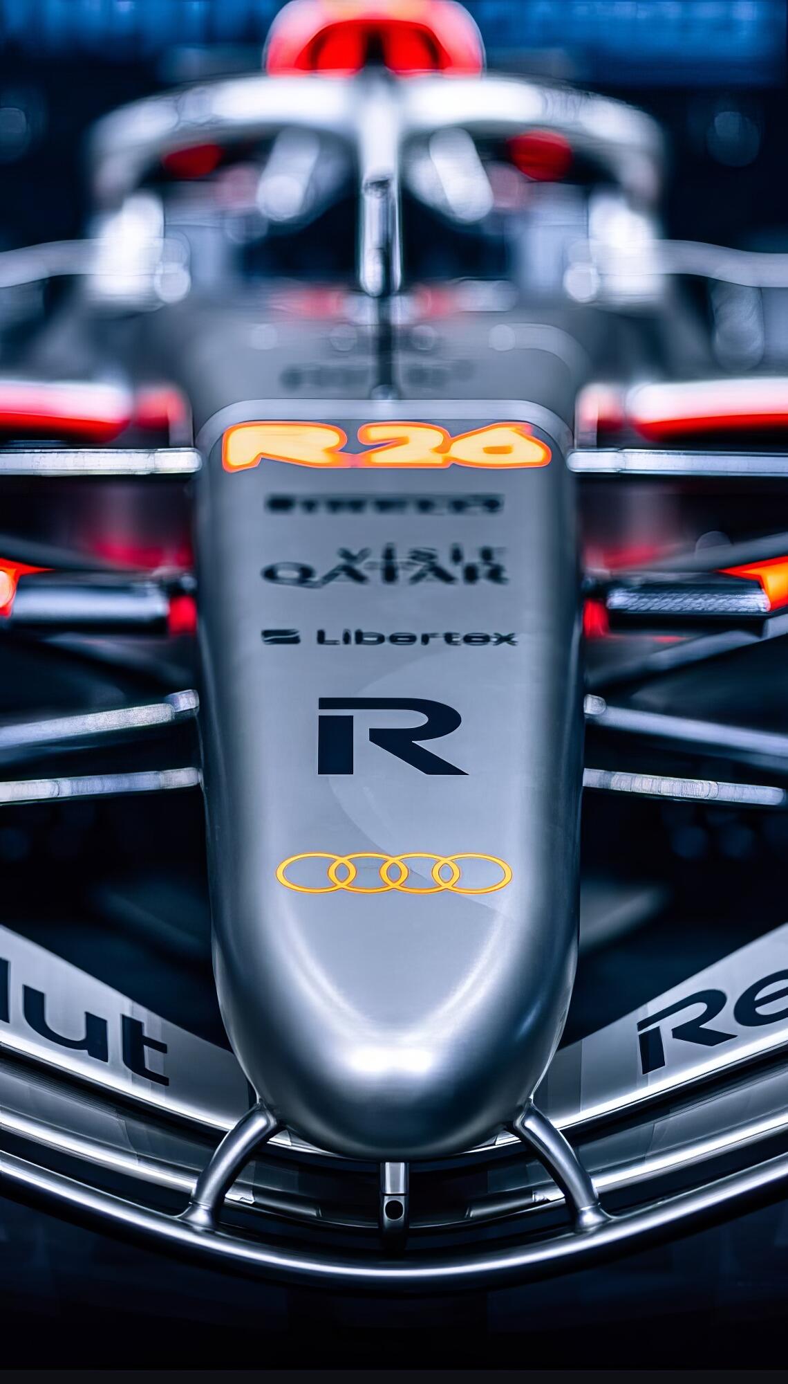 Phone wallpaper: close-up low-angle of Audi F1 vehicle nose and cockpit (R24 livery), halo and driver cockpit centered with visible team logos.