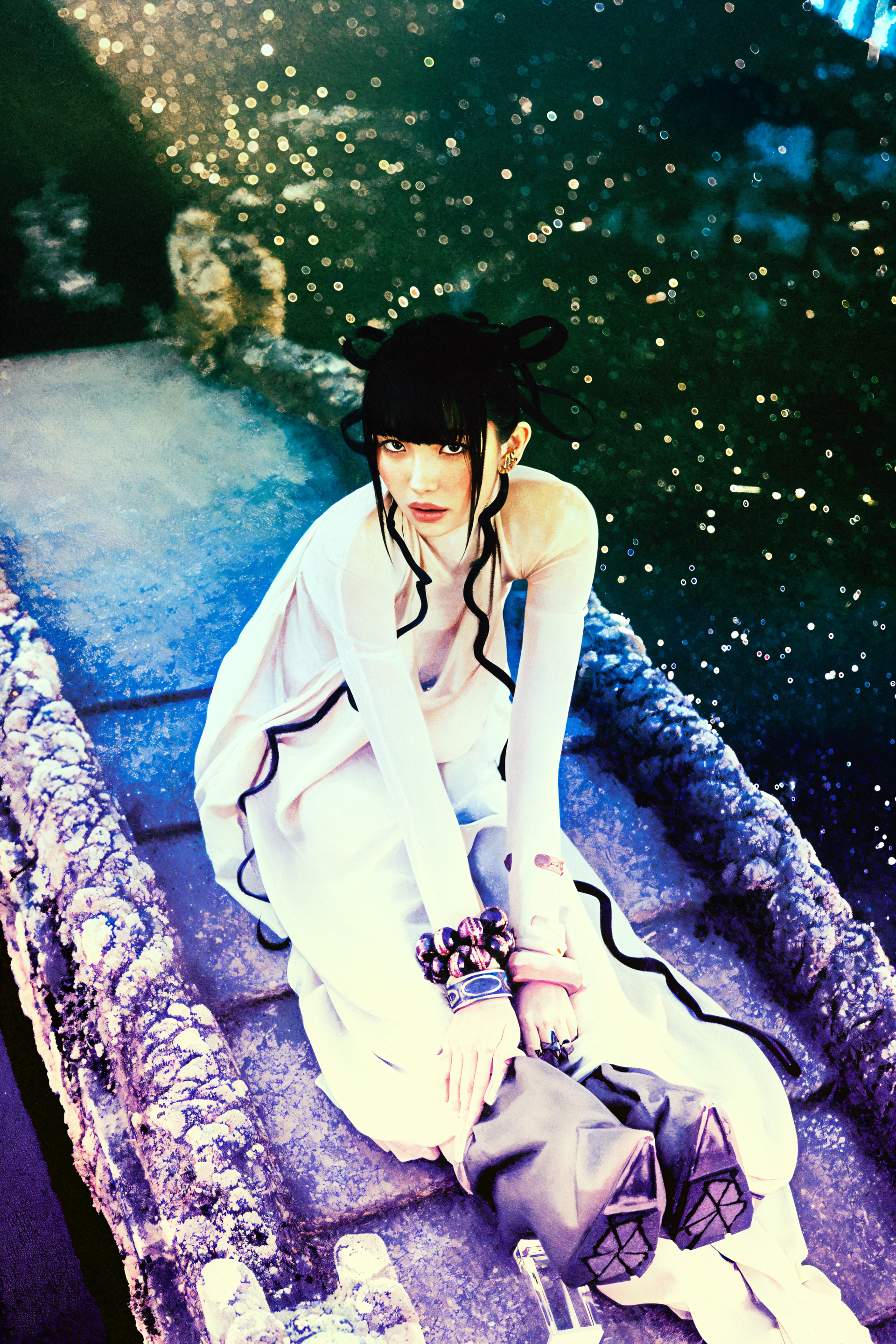 Woman cosplayer in a What a Wonderful Life costume seated on a stone bridge with sparkling bokeh, framed as a vertical iPhone wallpaper.