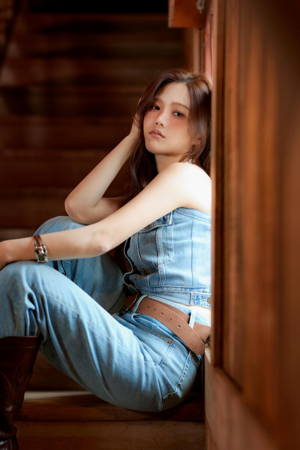 Hyojung of Oh My Girl poses in a denim outfit by a wooden doorway, captured in a stylish portrait phone wallpaper.