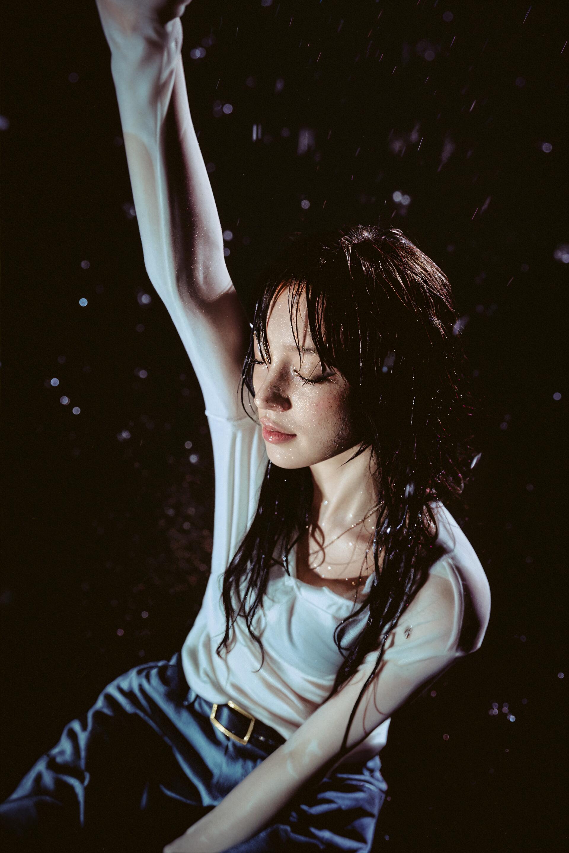Yuqi of (G)I-DLE poses with one arm raised against a dark, atmospheric background in this phone wallpaper.