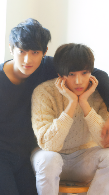 Phone wallpaper featuring EXO’s Kai from the Mama photoshoot, showing two softly lit portraits with warm, casual vibes for iPhone and Android.