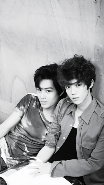 A monochrome photo of EXO members Kai and Suho from a photoshoot for Mama, featured as a stylish phone wallpaper. Both artists exude charisma in their casual outfits.