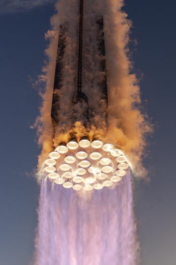A stunning close-up of the SpaceX Superheavy booster, showcasing powerful rocket engines ignited with vibrant exhaust plumes, set against a clear sky, designed for SpaceX Starship enthusiasts.