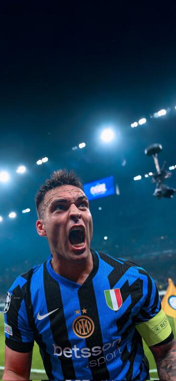 Close-up phone wallpaper of Inter Milan's Lautaro Martínez shouting passionately on the soccer field under stadium lights.