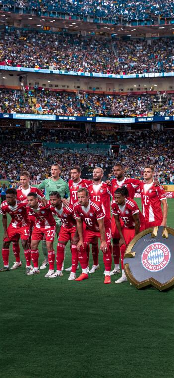 FC Bayern Munich soccer team poses on the field during the FIFA Club World Cup, captured in a vibrant stadium packed with fans.