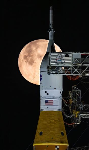 Phone wallpaper of the Artemis II rocket standing before a glowing full moon against a deep black night sky.