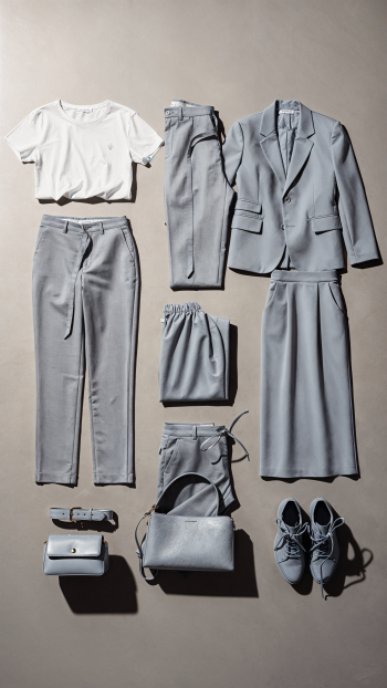 iPhone wallpaper flatlay of a capsule wardrobe: light gray blazer, trousers, skirt, cropped tee, bag, belt and sneakers on a neutral backdrop.