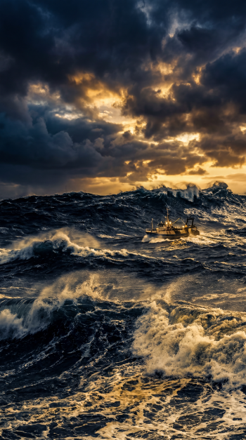 iPhone wallpaper of a stormy sea: a small boat fighting towering waves beneath dramatic, golden-streaked storm clouds.