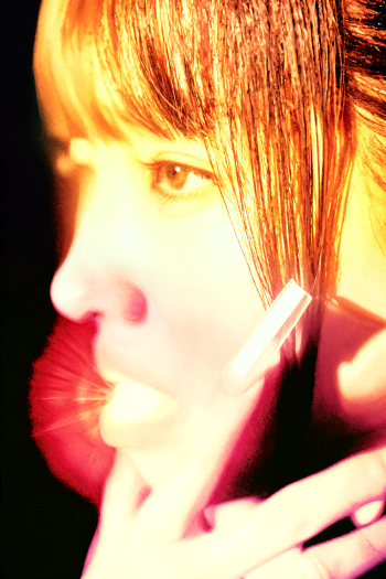 Close-up portrait of a woman's face in warm golden light, holding a phone; caption What a Wonderful Life — iPhone wallpaper.