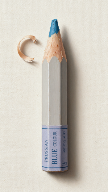 iPhone wallpaper: close-up colored pencil — a short Prussian Blue colored pencil with a sharpened blue tip and a crescent wood shaving on a pale background.