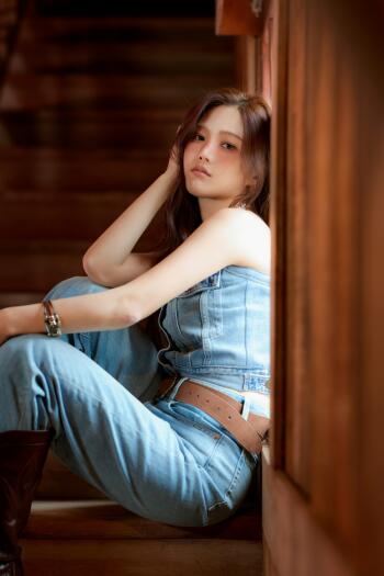 Hyojung of Oh My Girl poses in a denim outfit by a wooden doorway, captured in a stylish portrait phone wallpaper.