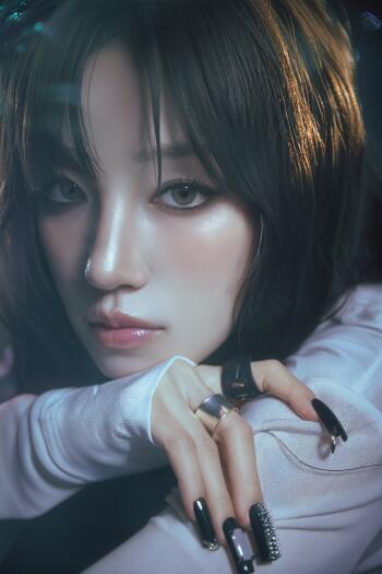 Close-up portrait of Yuqi from (G)I-DLE with dark hair and silver nails, featured in a moody iPhone wallpaper.