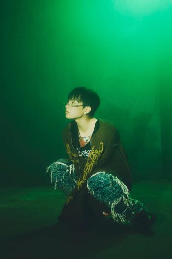 ATEEZ Hongjoong portrait in moody green lighting, wearing glasses and distressed jeans, from Golden Hour phone wallpaper.