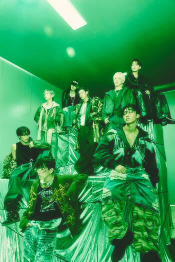 ATEEZ Golden Hour group portrait in bold streetwear under green lighting, styled as an iPhone wallpaper.