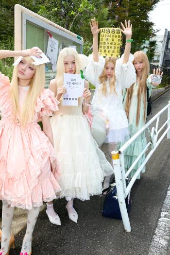 ILLIT women pose in pastel ruffled dresses outdoors in this Break Even fashion photo phone wallpaper.