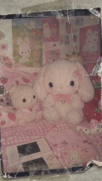 Cutecore iPhone wallpaper with soft white stuffed rabbit plush toys in a pastel pink bunny-themed room.