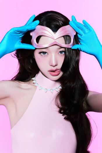 Jang Wonyoung of IVE in a bold pink Looks Can Kill portrait, wearing a sculptural mask and blue gloves, phone wallpaper.