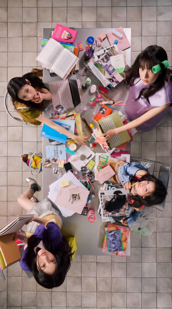 ILLIT BREAK EVEN iPhone wallpaper featuring GLLIT students studying together at a desk scattered with books, notes, and supplies.