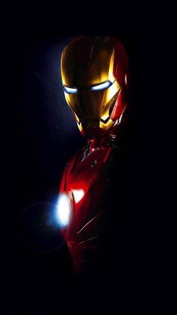 Phone wallpaper featuring a dark background with Iron Man's glowing eyes and arc reactor, designed for both iPhone and Android devices, inspired by the Iron Man movie.