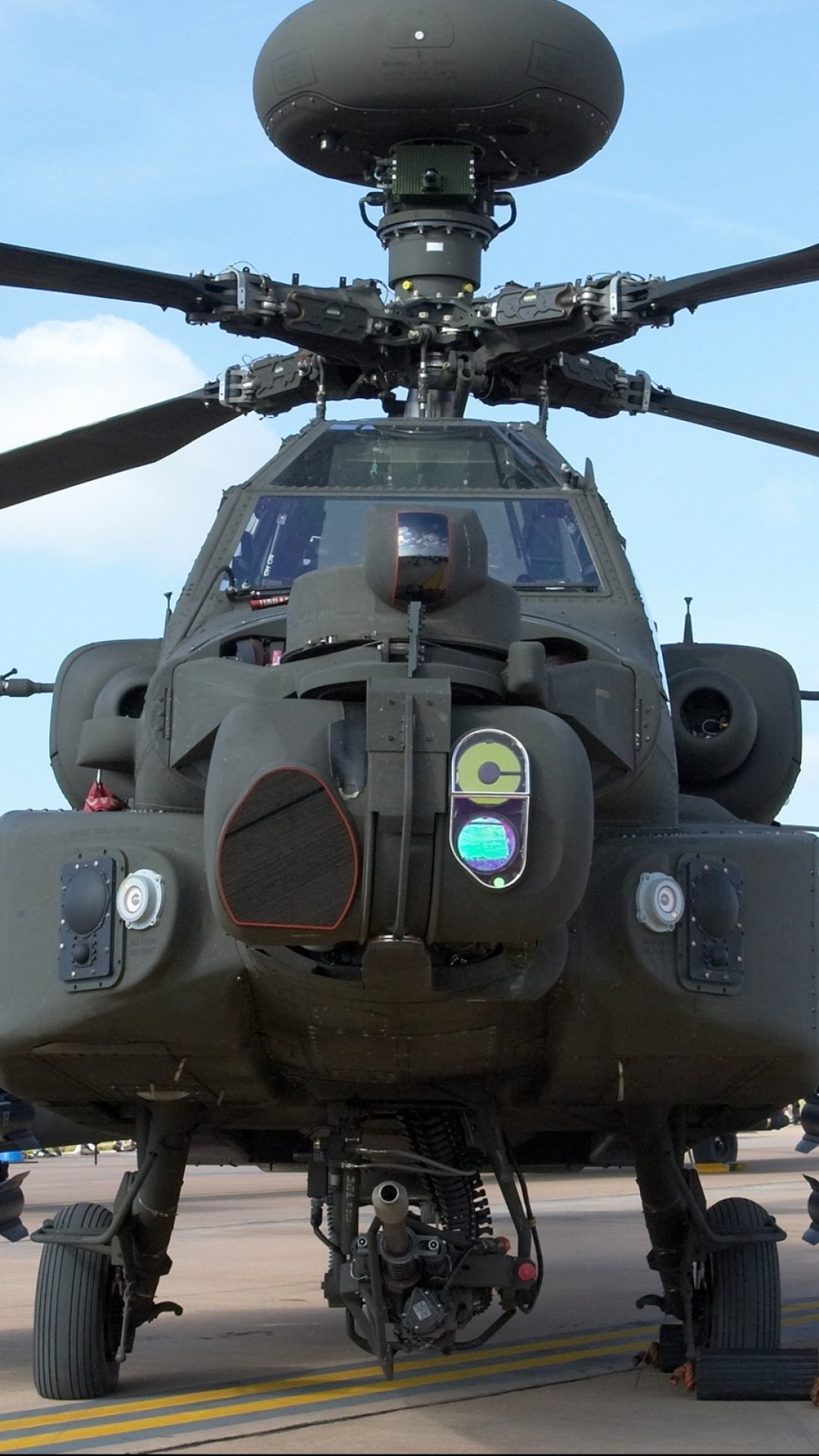 Vertical phone wallpaper: close frontal view of a military Boeing AH-64 Apache attack helicopter with rotor mast, sensor turret and landing gear.