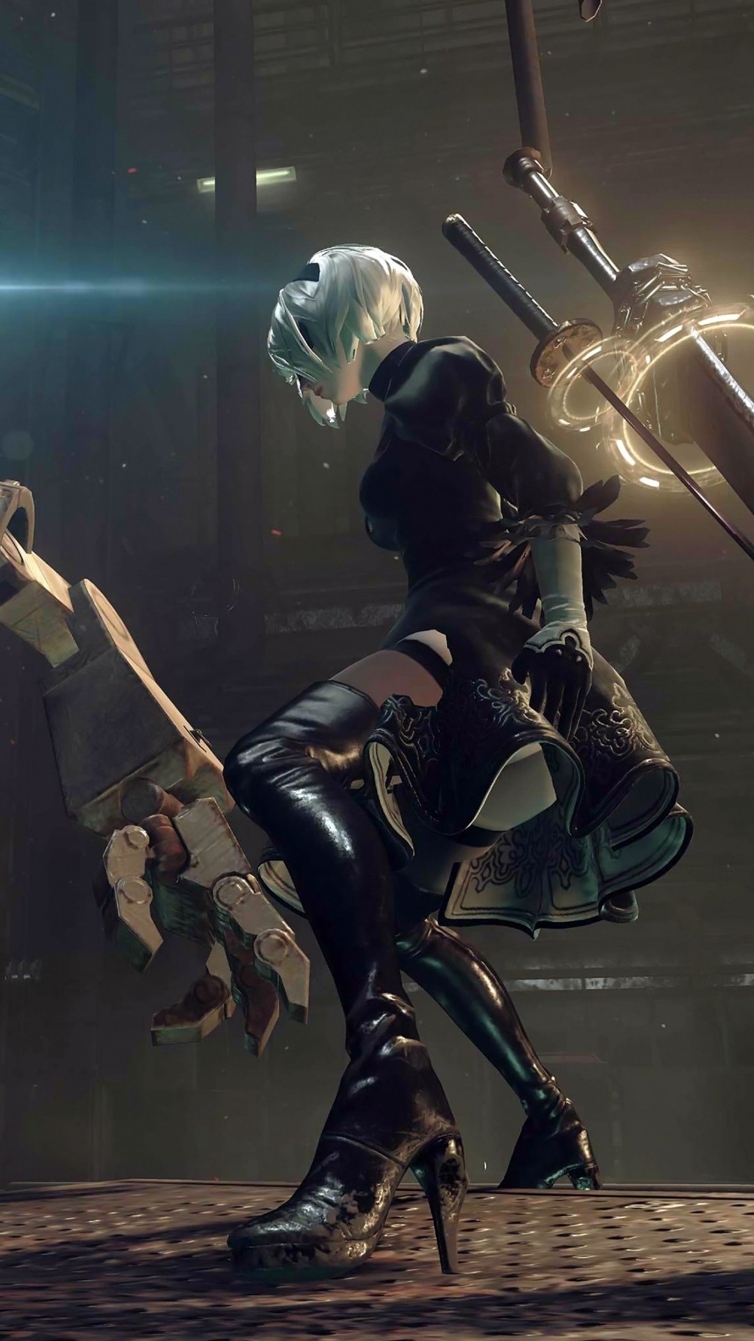 Phone wallpaper featuring 2B from the video game NieR: Automata kneeling in a dim industrial interior, blades floating behind her under dramatic lighting.