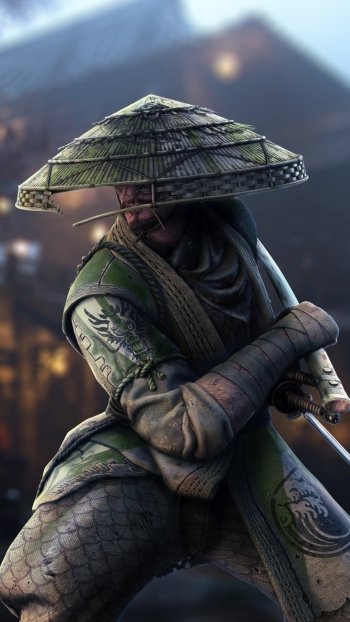 Phone wallpaper of a For Honor video game samurai warrior in a straw hat and green armor, crouched with sword against a blurred village night backdrop.