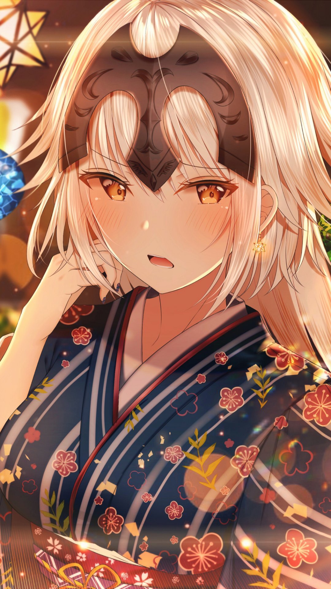 Anime phone wallpaper: Jeanne d'Arc Alter (Avenger, Fate/Grand Order) close-up, blonde hair, yellow eyes and a faint blush, wearing a floral kimono beneath warm, glowing lantern light.