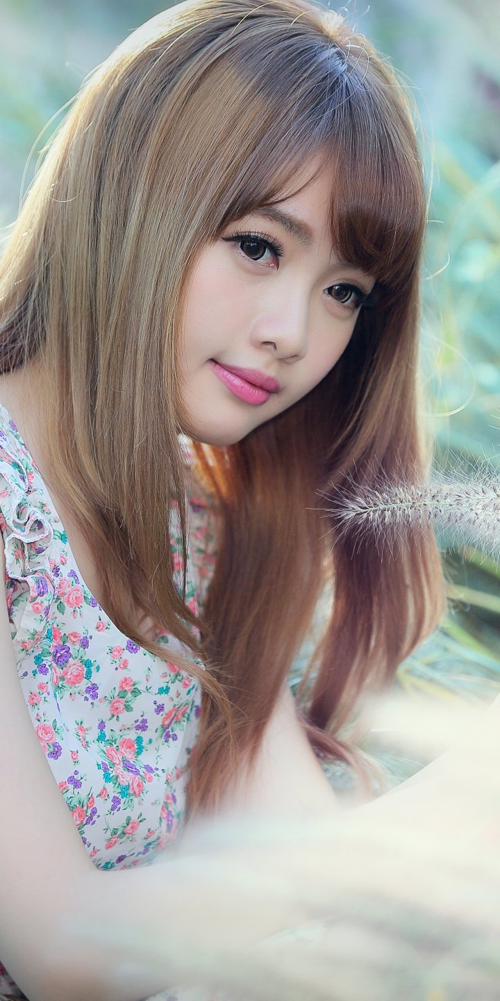 Portrait of Taiwanese model Cubie Wang with soft makeup and long hair, set against a blurred natural background, designed as a phone wallpaper for iPhone and Android.