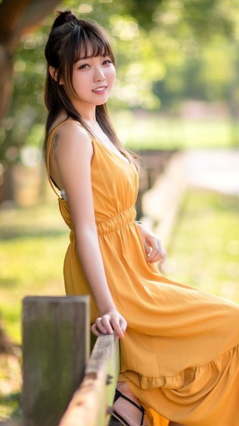 brunette smile yellow dress depth of field model woman asian Phone Wallpaper