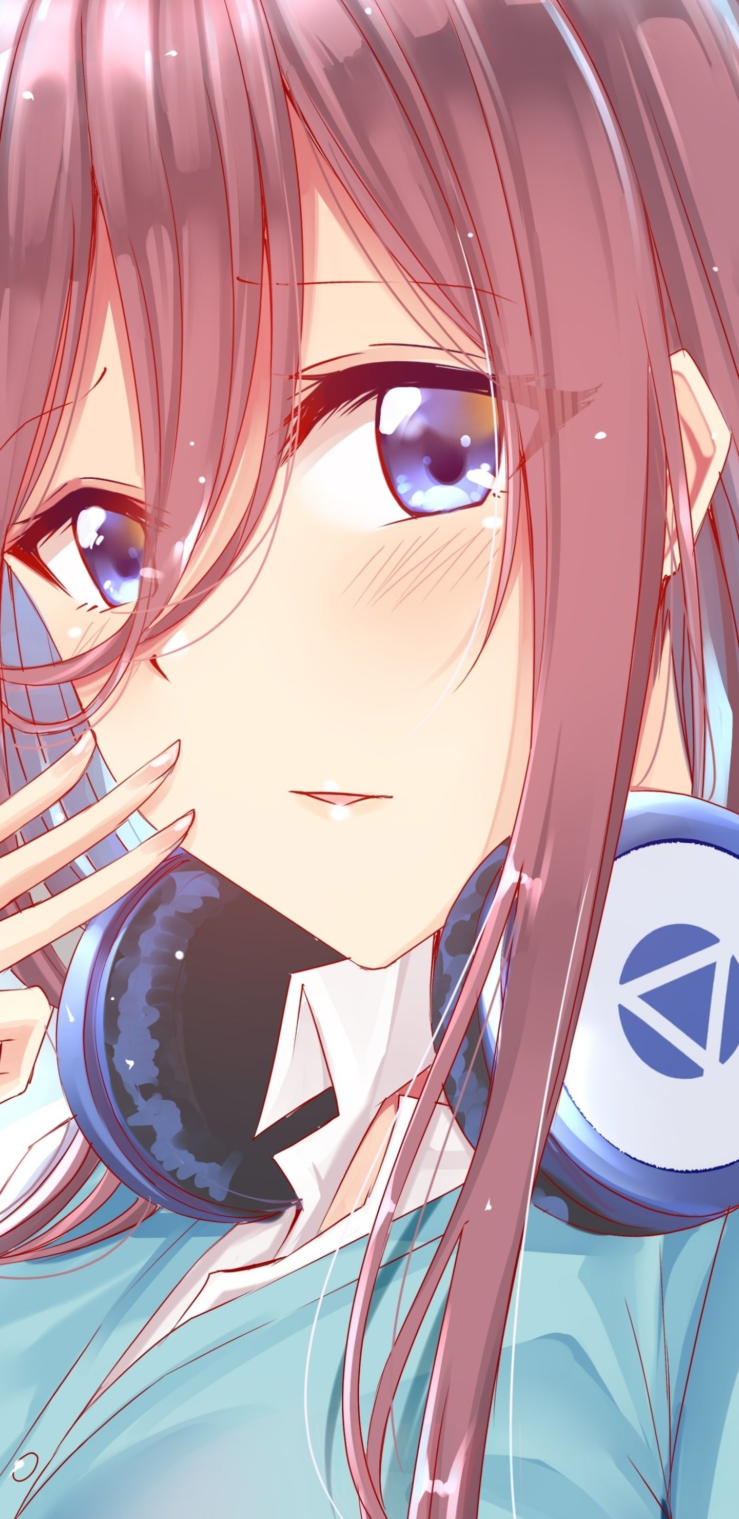 Phone wallpaper of Miku Nakano from The Quintessential Quintuplets — close-up portrait with soft blush, long pinkish-brown hair, bright blue eyes and blue headphones.