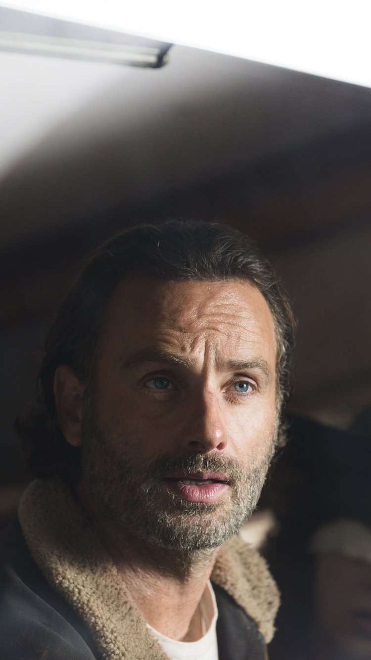 Phone wallpaper close-up of a bearded man as a rugged survivor from the TV series The Walking Dead, soft light on his face and a worn shearling jacket.