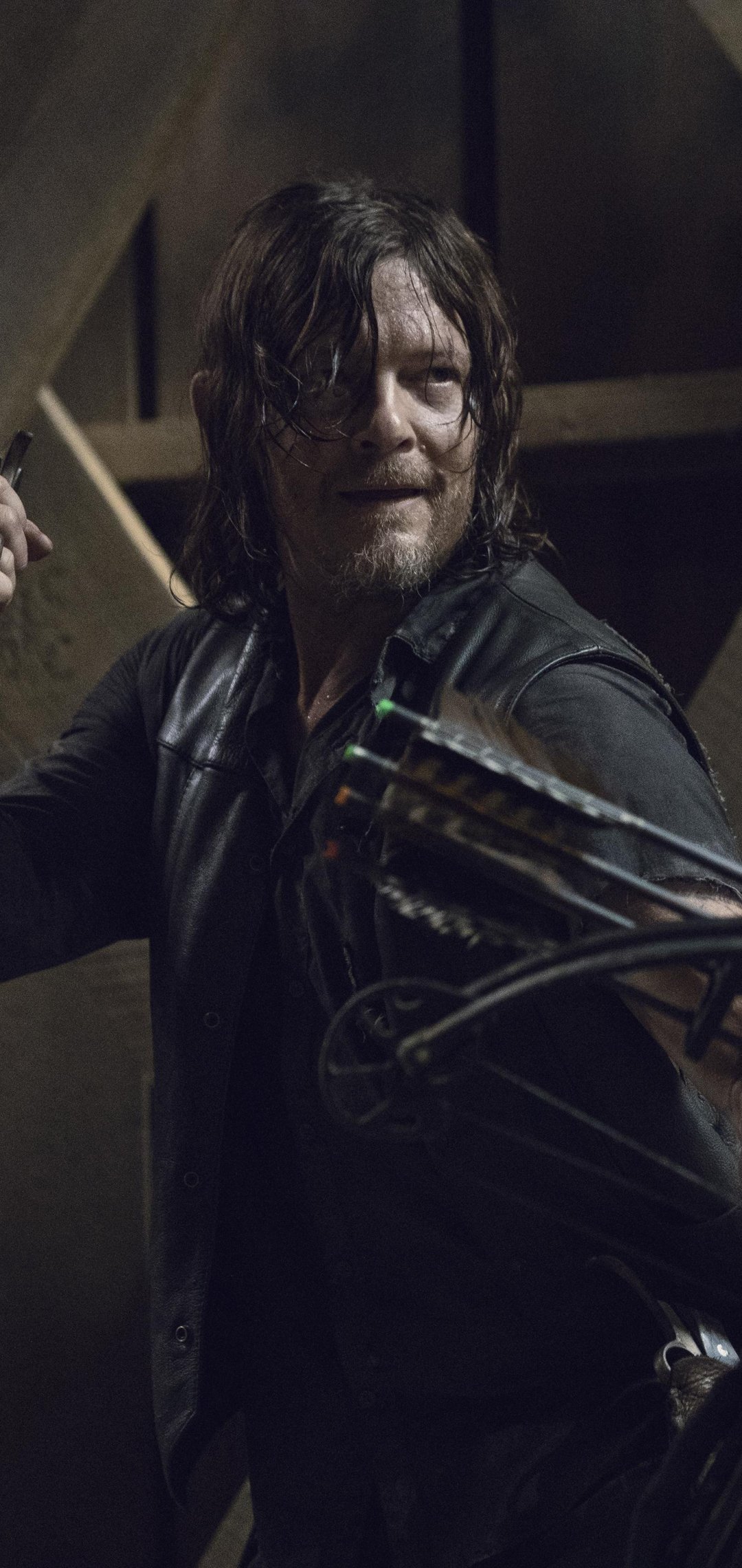 Phone wallpaper of Daryl Dixon from The Walking Dead — grim, rain-soaked, leather jacket and crossbow, staring determinedly into the dark, ready for action.