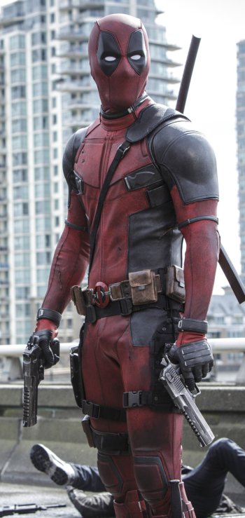 Phone wallpaper of Deadpool from the movie, standing on a rooftop with two pistols and a katana, city skyline in the background.