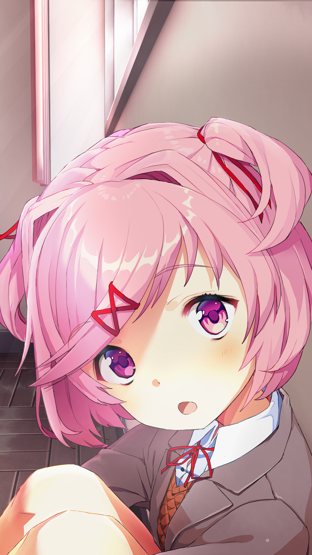 Phone wallpaper of Natsuki (Doki Doki Literature Club!), a pink‑haired anime girl with ribboned hair and school uniform, looking up in a dim hallway — video game art style.