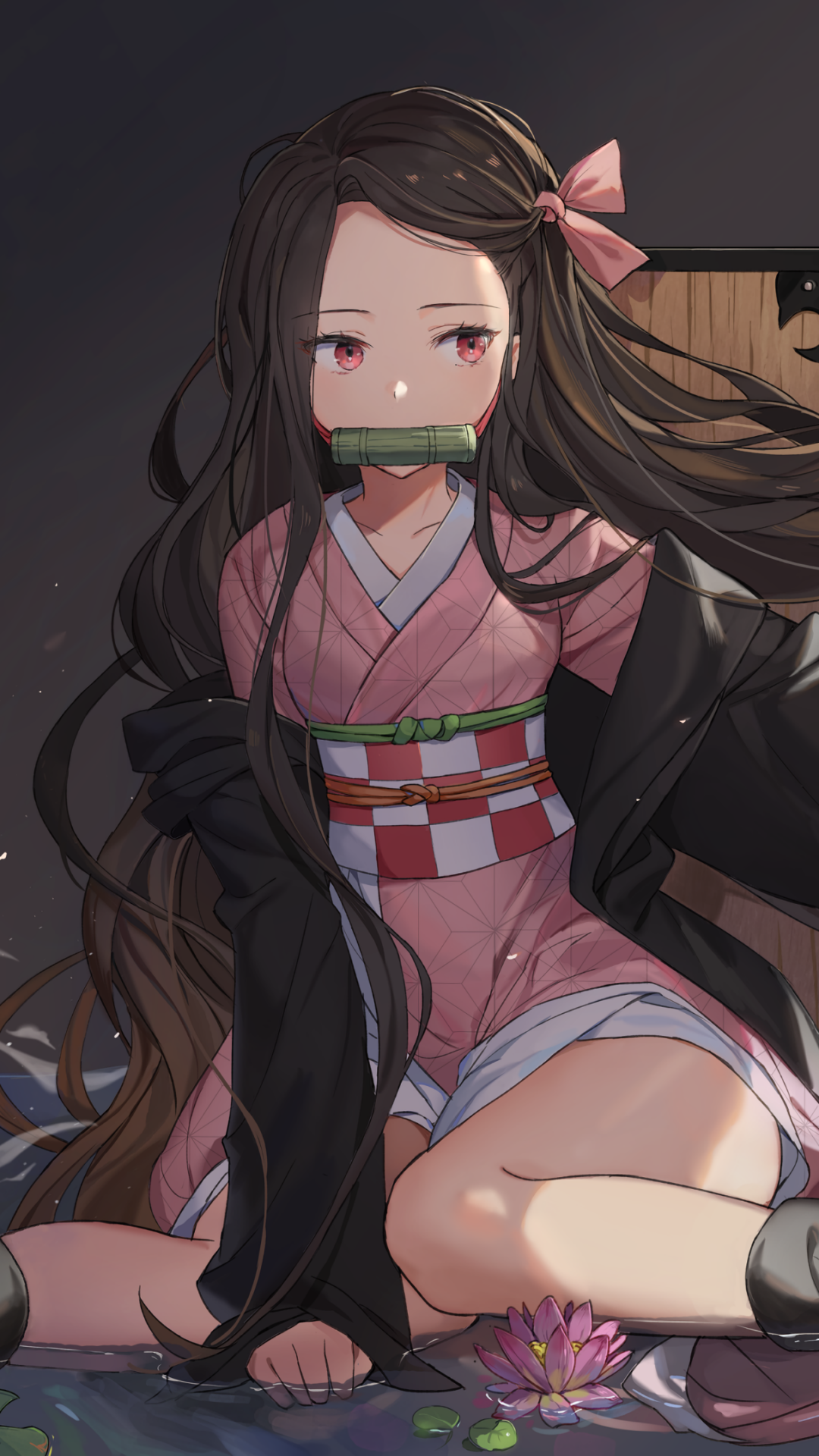 Nezuko Kamado (Demon Slayer: Kimetsu no Yaiba) phone wallpaper — seated in a pink kimono with a bamboo muzzle, flowing hair and dark haori, lotus at her feet against a soft lantern-lit background.