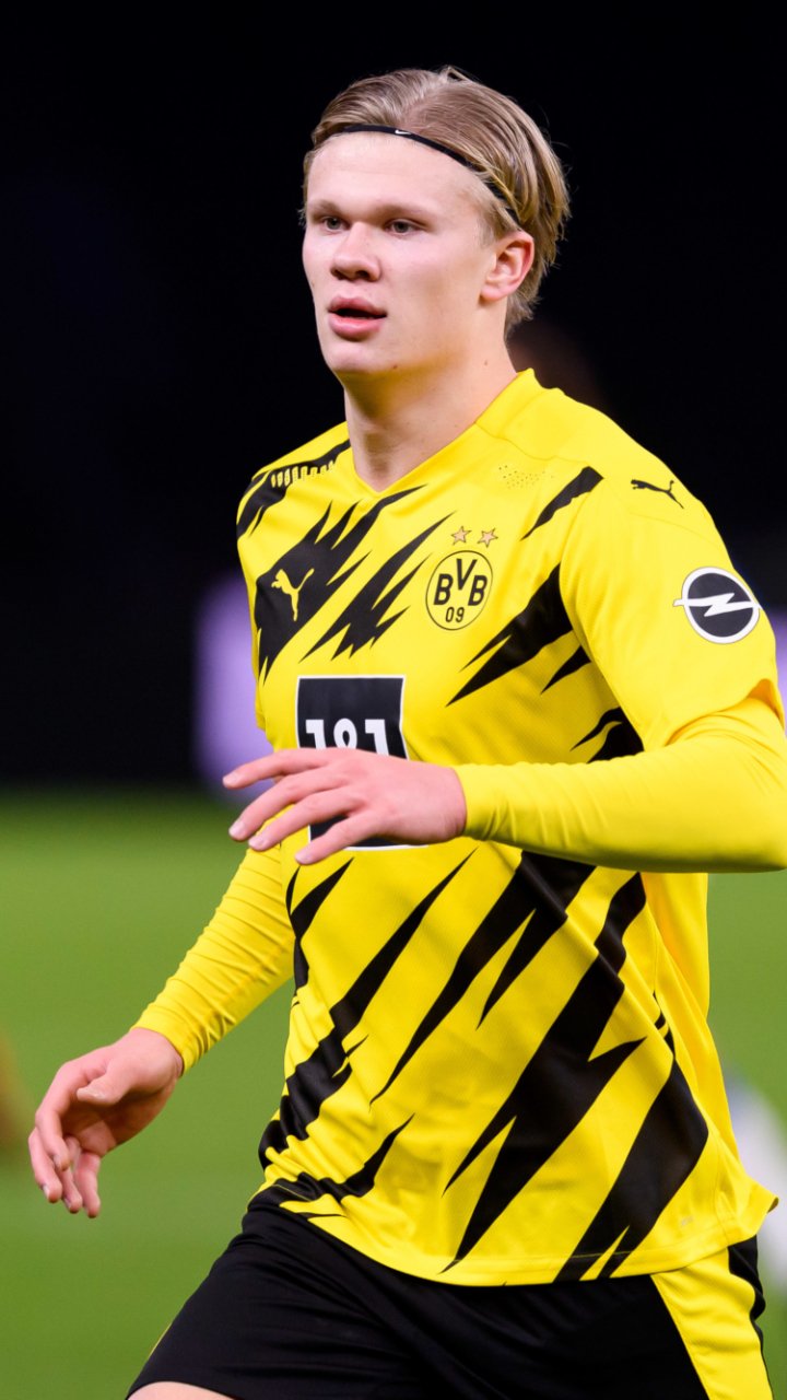 Phone wallpaper of a Norwegian soccer star in Borussia Dortmund yellow-and-black kit, mid-match action portrait conveying speed, focus and athletic intensity — sports-themed.