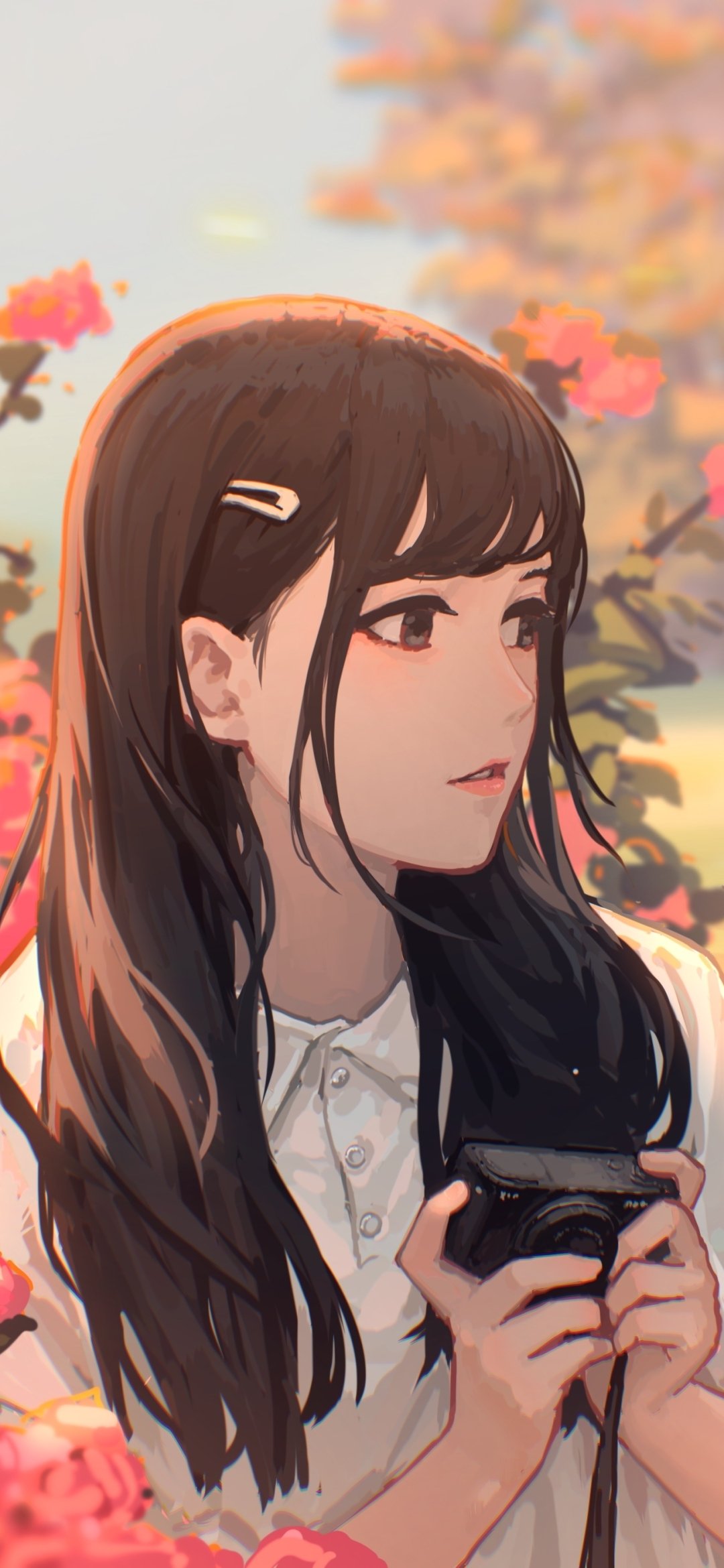 Phone wallpaper featuring an anime girl in profile holding a camera among pink blossoms, long dark hair, soft pastel colors and warm evening light.