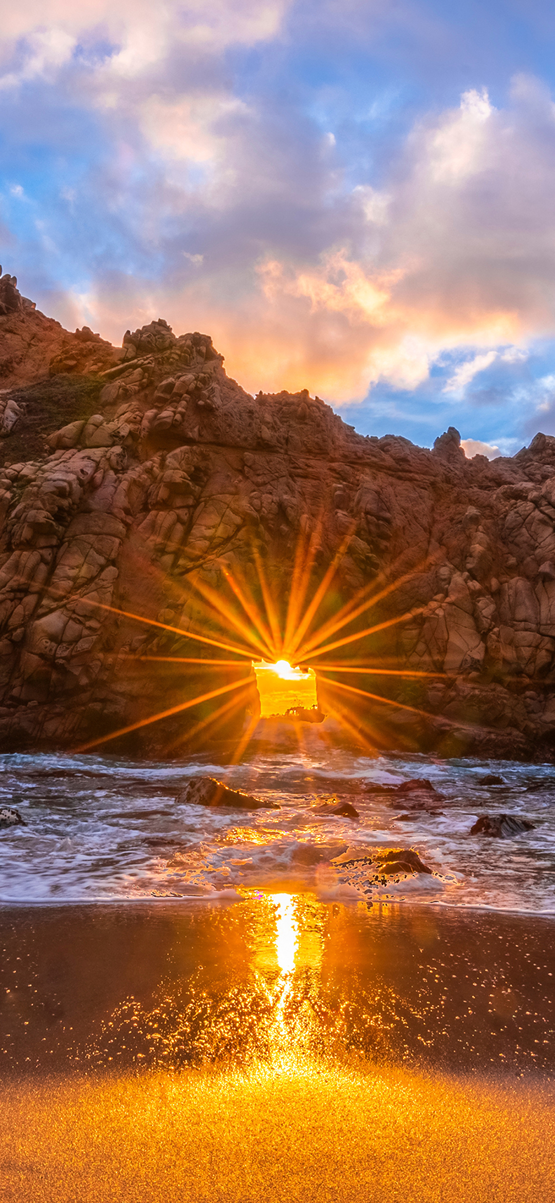 Rays of light through an arch on the beach