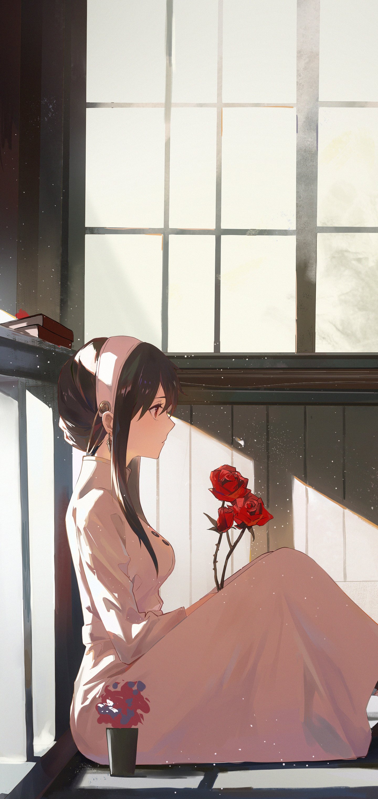 Yor Forger from Spy x Family sits quietly by a sunlit window holding red roses, featured in an anime-style phone wallpaper for iPhone and Android.